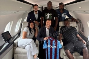 奥纳纳与家人、经纪人在飞机上合影，展示特拉布宗体育球衣